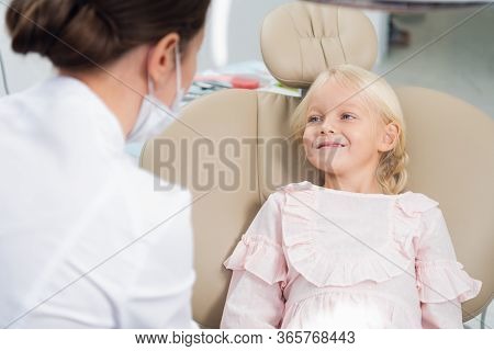 A Cute Little Girl At The Dentists Office Talking To Her Pediat