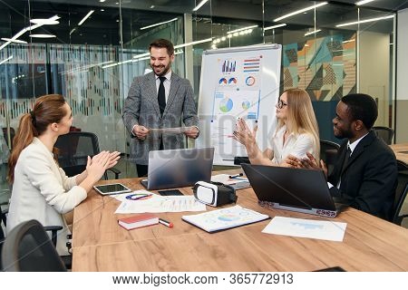 Good-looking High-skilled Male Business Mentor Explaining To His Attantive Business Group Consist Of