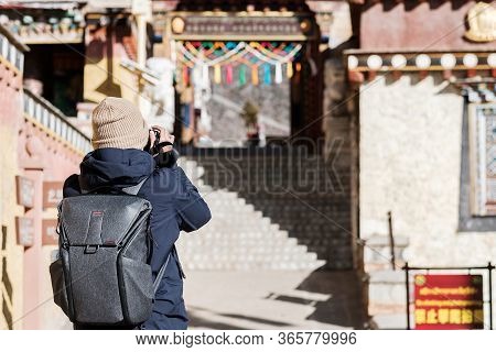 Young Man Traveler With Sweater And Backpack Traveling In Songzanlin Temple, Happy Photographer Taki