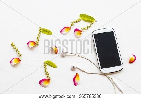 Mobile Phone ,earphone With Petal Coloful Flowrers Frangipani Arrangement Music Score Flat Lay Style