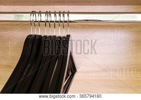 Close-up Many Empty Black Clothing Racks Hanging On Coathanger In Closet With Copy Space