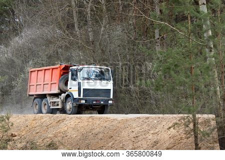 Grodno, Belarus - April 2020: Heavy Laden Multi-ton Truck With White Cab And Orange Body Rides Along