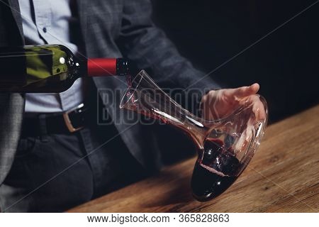 Sommelier Man Pours Red Wine Into Decanter For Aeration Of Taste And Aroma