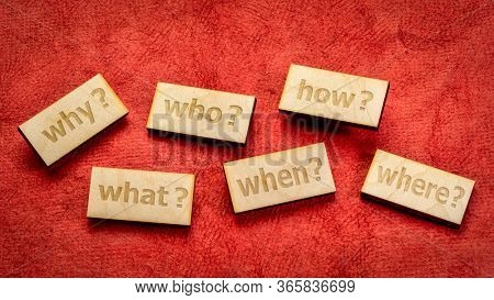 decision making or brainstorming questions - text engraved in wooden block against red textured paper background