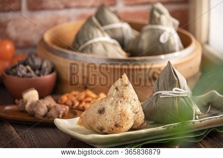 Zongzi - Chinese Rice Dumpling Zongzi In A Steamer On Wooden Table With Red Brick, Window Background