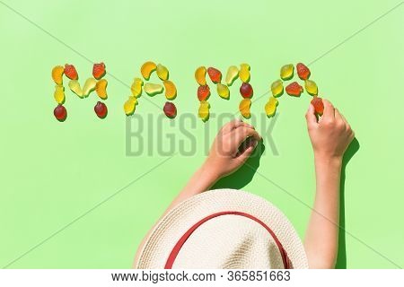 Childs Hands Making Word Mama With Jelly Candies