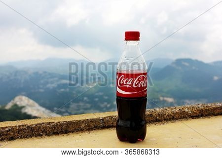 Lovchen, Montenegro - July 16, 2012: Plastic Bottle Of Coca-cola Drink Against Nature Background Wit
