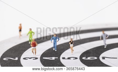 Miniature People Running On Dart Board , Healthy Concept