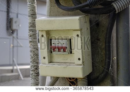 Old Three-pole Electric Switch On A Concrete Pillar Outdoors.