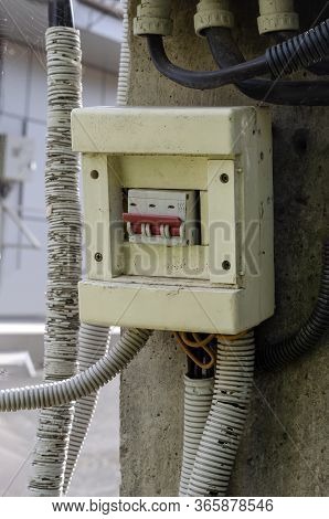 Old Three-pole Electric Switch On A Concrete Pillar Outdoors.