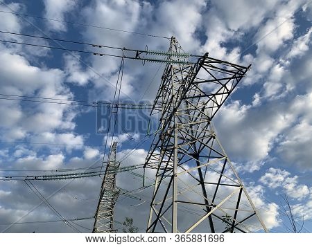 High Voltage Electric Tower Against The Blue Sky. High Steel Power Pole, Among The Forest. High Volt