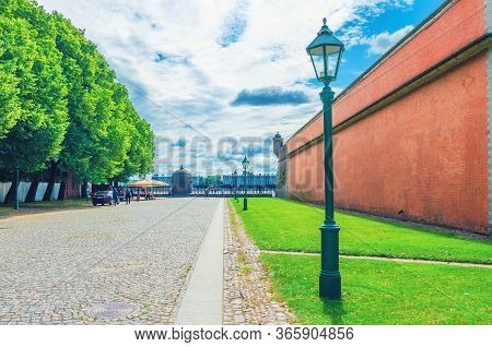 Fortress Brick Wall, Street Light And Green Trees In Peter And Paul Fortress Citadel On Zayachy Hare