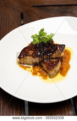 Grilled Foie gras, grilled duck and goose live poultry, with plum savory sauce. Gourmet internationl cuisine recipe using for buffet food and drink concept.