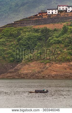 Zigui, China - May 6, 2010: Xiling Gorge On Yangtze River. Small Sloop With Sailor On Brownish Water
