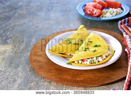 Chilla, Tortillas Or Pancakes Made From Chickpea Flour Stuffed With Cheese Panir And Tomato On A Whi