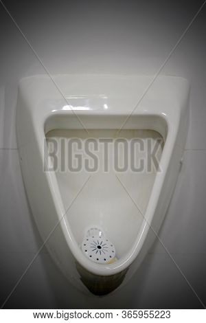 Closeup Of Toilet Bowl. White Man Toilet In The Bathroom. Public Toilet In The Airport Or Restaurant