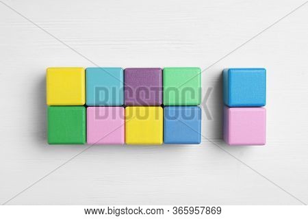 Flat Lay Composition With Colorful Cubes On White Wooden Background. Pareto Principle Concept