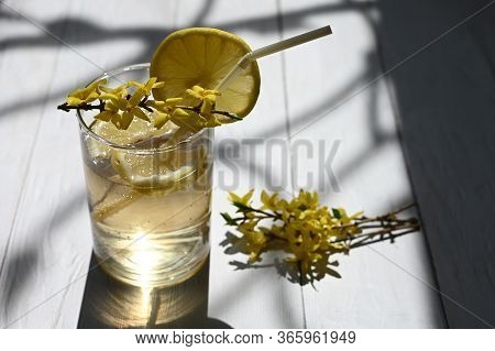 Fresh Lemonade Decorated With Yellow Flowers On The Table.