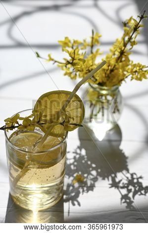 Fresh Lemonade With Yellow Flowers On The Table.