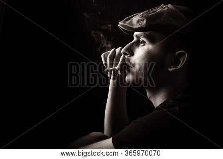 Black And White Profile Portrait Of Cute Young Guy With Moustache And A Hat On Black, Dark Backgroun