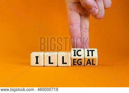 Illegal Or Illicit Symbol. Businessman Turns Wooden Cubes And Changes The Concept Word Illegal To Il