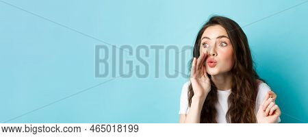 Cute Glamour Gossip Girl Spreading Rumours, Whispering News To Someone, Standing Voer Blue Backgroun