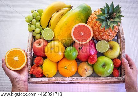 Wooden Basket Full Of Fresh Fruit On A White Background. Citrus Fruits, Papaya, Pineapple, Banana, P