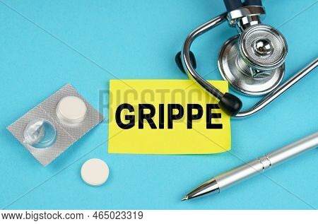 Medical Concept. On A Blue Surface, A Stethoscope, Pills, A Pen And A Yellow Sticker With The Inscri