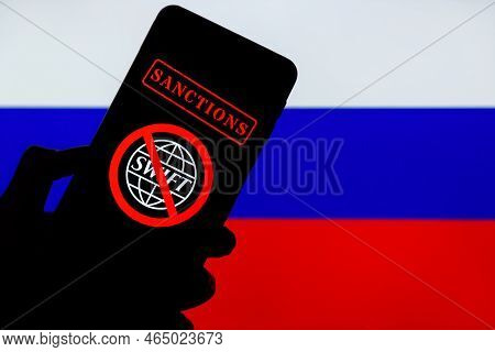 Ukraine, Kiev - February, 23 2022: Silhouette Of Black Hand Holding Mobile With Crossed Out Swift Lo