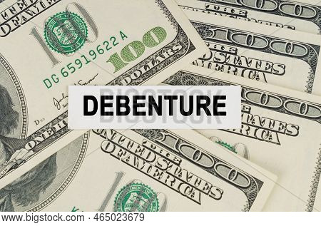 Business Concept. On The Dollars Lies A Paper Plate With The Inscription - Debenture