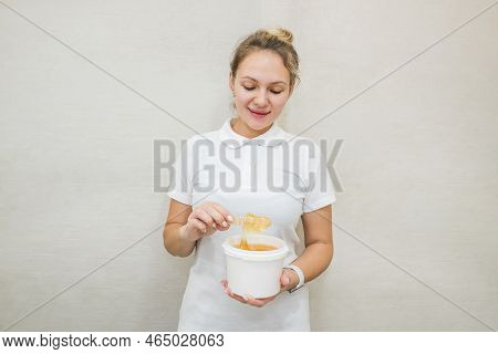 Portrait Of A Woman With A Jar Of Sugar Paste For Sugaring.beautician Holding A Jar Of Sugar Paste F