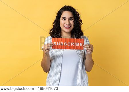 Portrait Of Happy Smiling Positive Woman With Dark Wavy Hair Holding Red Card With Subscribe Inscrip