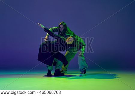 Modern Dance Concept. Energetic Couple Of Two Young Woman Dancing Contemporary Dance On Gradient Blu