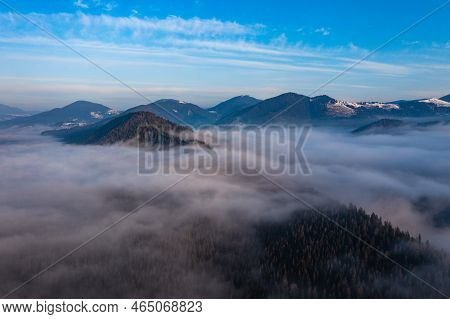 A Panoramic View From Above Of The Mountain Peaks In Thick Clouds.