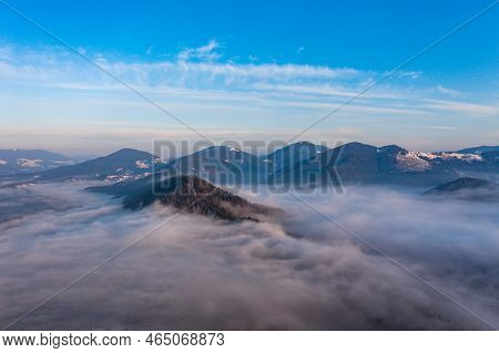 A Panoramic View From Above Of The Mountain Peaks In Thick Clouds.