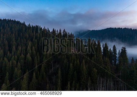 A Panoramic View From Above Of The Mountain Peaks In Thick Clouds.
