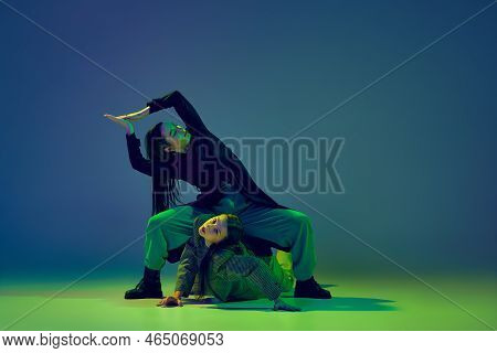 Young Stylish Flexible Girls In Modern Attires Dancing Contemp Style Dance Isolated Over Gradient Bl