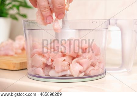 A Man Puts Pieces Of Defrosted Raw Chicken Fillet Into The Bowl Of A Food Processor. Mince, Grind, K