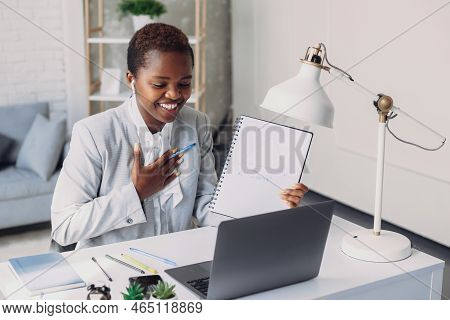 Black Female Tutor Having Video Call With Students, Talking At Laptop Camera, Sitting At Table At Ho