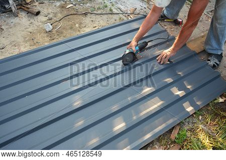 Roofer Cutting Lightweight Metal Roof Sheet With Grinding Machine. Roofing Construction.