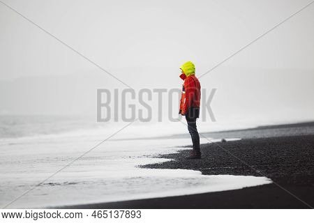 Man In Red Jacket Standing On Reynisfjara Beach