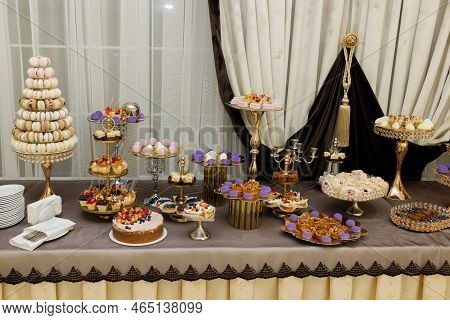 Table With Cakes, Sweets, Candy, Buffet. Dessert Table For A Party Goodies For The Wedding Banquet A