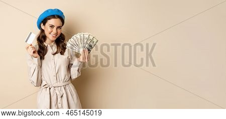 Microcredit And Money Concept. Young Stylish Woman Showing Credit Card And Dollars Cash, Smiling Hap