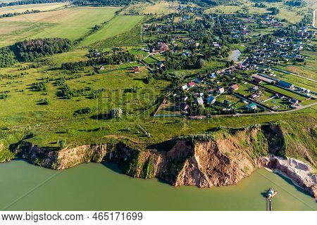 View From A Great Height On The Slope Of A Flooded Sand Pit Against The Background Of The Village Of