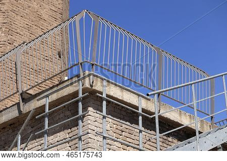 A Steel Railing Installed On The Terrace Of A Gray Brick Building