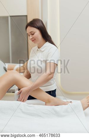 Cosmetologist Using Endospheres Therapy Machine On Females Legs