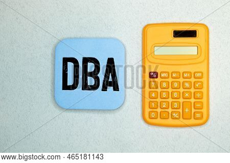 Dba - Text Is Made Up Of Letters On Wooden Cubes Lying On A Mirror Surface, Gray Background. Stacks 