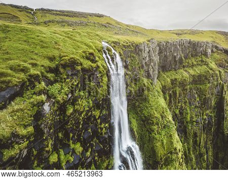 Aerial View Of The Top Of The Waterfall Running Over Moss Covered Rocks In Iceland