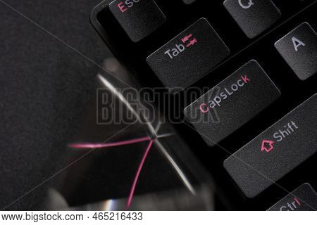 Fragment Of A Black Professional Mechanical Computer Keyboard And A Glass Prism On A Black Backgroun