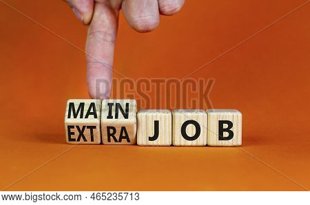 Extra Or Main Job Symbol. Businessman Turns Wooden Cubes And Changes Concept Words Extra Job To Main